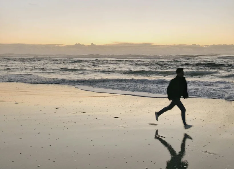 Pessoa a correr na praia a explorar- Alojamentos com Alma